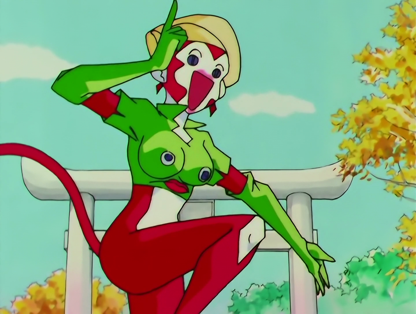 ManeMane Musume, a Lemures from Sailor Moon episode 152. She resembles an anthropomorphic monkey, with red and white skin and a long red tail. She wears a green shirt with a face on it, the eyes positioned on her boobs, and green gloves. She has a beige hat, and her expression is drawn in a fairly simplistic way, with round black dots for eyes and a wide open mouth.
